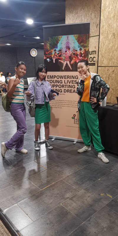 Girls posing in front of a poster
