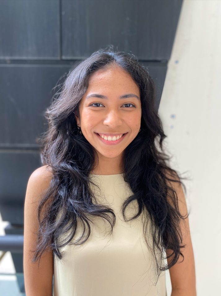 smiling-young-woman-portrait-in-beige-top Portrait of a young woman with long dark wavy hair smiling warmly at the camera