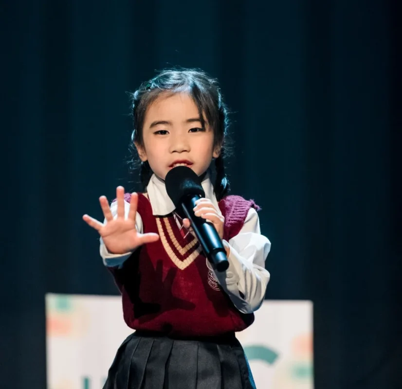 young-girl-performing-singing-with-microphone-on-stage Best Singing School Singapore